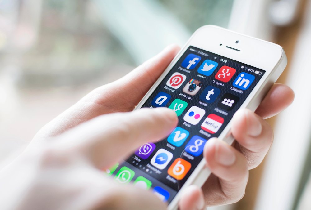 A phone user looking at social media apps on his phone