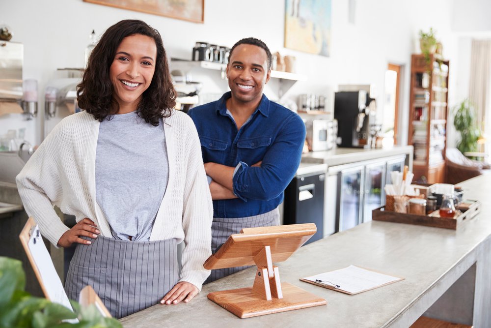 Mixed race couple behind counter at coffee shop